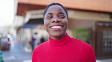 African american woman smiling confident standing at coffee shop terrace