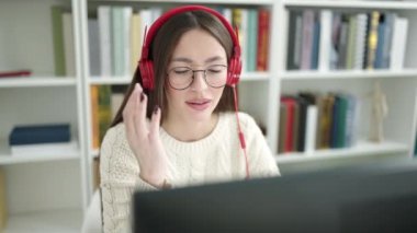 Kütüphanede kulaklık takan güzel bir İspanyol kadın.