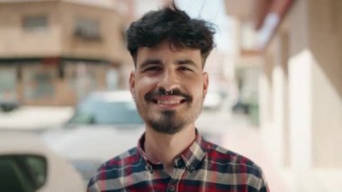 Sokakta kendinden emin gülümseyen İspanyol genç adam.