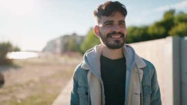 Sokakta kendinden emin gülümseyen İspanyol genç adam.