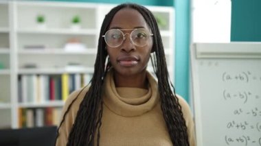 African woman smiling confident by maths magnetic board at library university