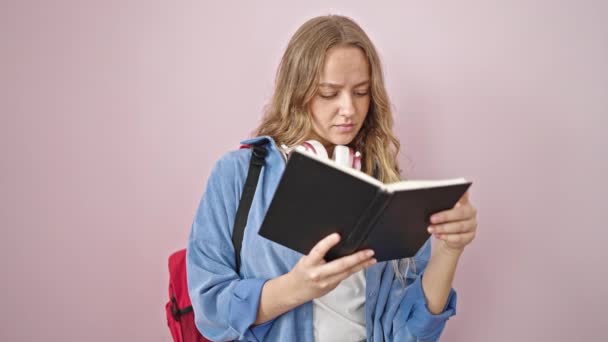 Młoda Blondynka Student Czytanie Książki Wątpliwościami Wyrażenia Odosobnionym Różowym Tle — Wideo stockowe