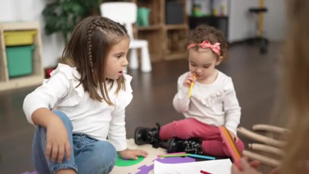 两个小女孩坐在幼儿园的地板上 在笔记本上画画 — 图库视频影像