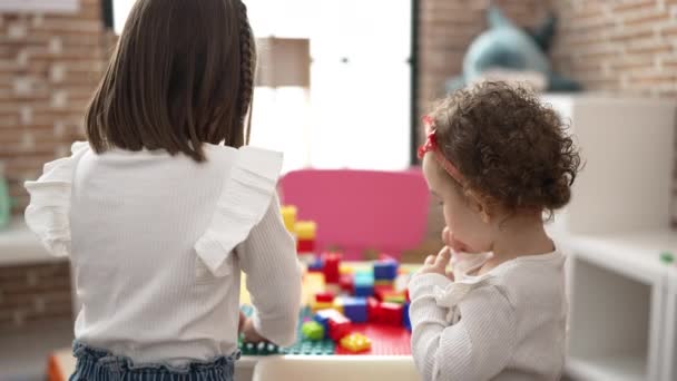2人の女の子遊びます建設ブロックピース立って幼稚園 — ストック動画