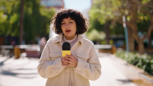 Молодая Латиноамериканка Репортер Говорит Помощью Микрофона Парке — стоковое видео