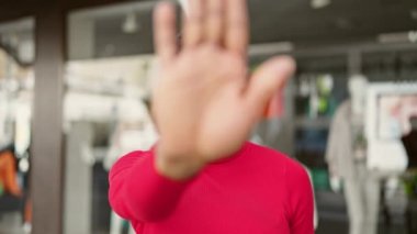 Afro-Amerikalı kadın sokakta el hareketlerini durduruyor.