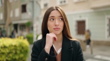 Sokakta şüpheli bir ifadeyle duran genç İspanyol kadın.