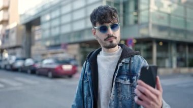Genç İspanyol adam gülümsüyor. Kendine güveni tam. Akıllı telefonuyla özçekim yapıyor.
