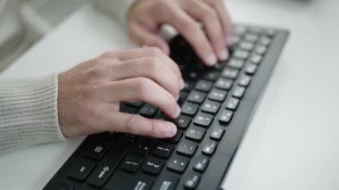 Ofiste bilgisayar klavyesi kullanan genç bir İspanyol.