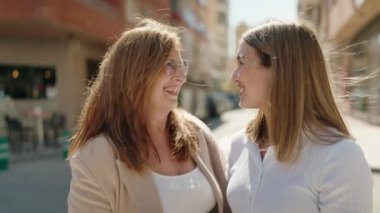 Anne ve kızı sokakta bir arada konuşuyorlar.