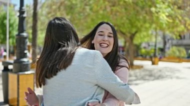 Parkta birbirine sarılan iki kadın.