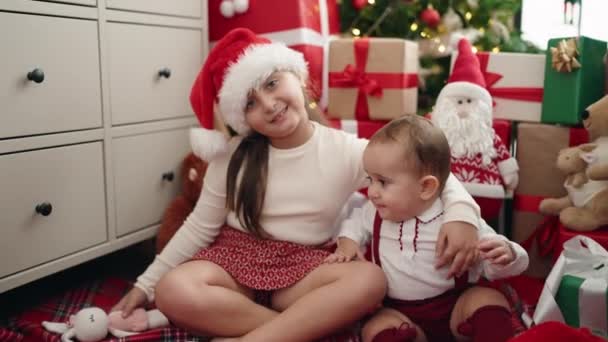 姐妹俩坐在地板上互相拥抱 在家里送圣诞礼物 — 图库视频影像