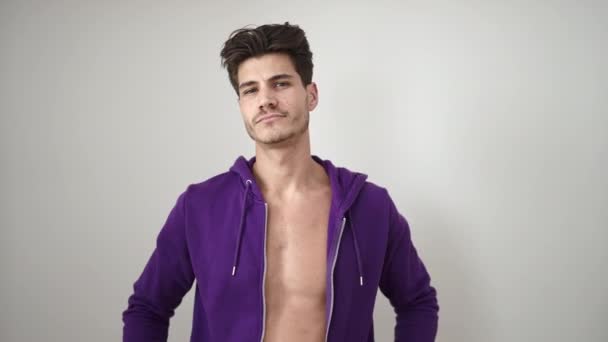Junger Hispanischer Mann Lächelt Selbstbewusst Und Zieht Sweatshirt Über Isoliertem — Stockvideo