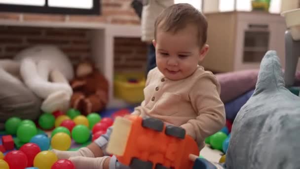Anaokulunun Zemininde Oturan Iki Küçük Bebek Top Arabayla Oynuyorlar — Stok video