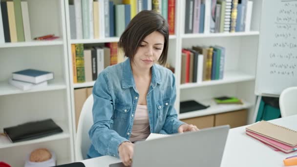 大学の教室でノートパソコンを使ってノートを書く若い白人女性学生 — ストック動画