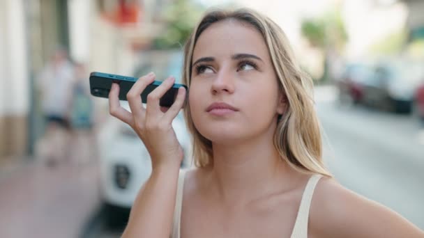 Jonge Blonde Vrouw Luisteren Audioboodschap Door Smartphone Met Serieuze Expressie — Stockvideo