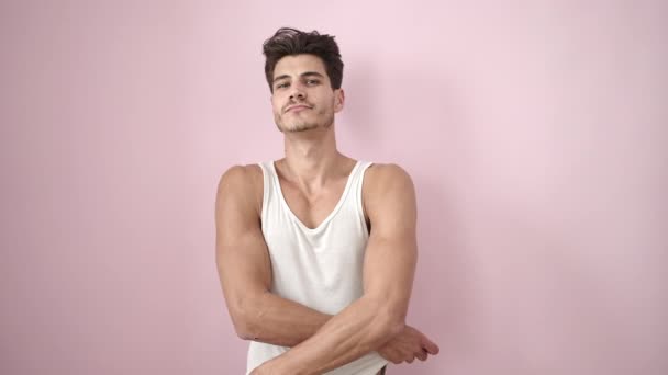 Joven Hombre Hispano Sonriendo Confiado Quitándose Camiseta Sobre Fondo Rosa — Vídeos de Stock