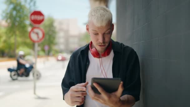 Young Caucasian Man Using Touchpad Wearing Headphones Street — Stockvideo
