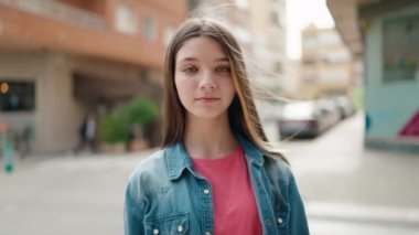Adorable girl smiling confident looking to the camera at street