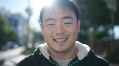 Young chinese man smiling confident standing at street