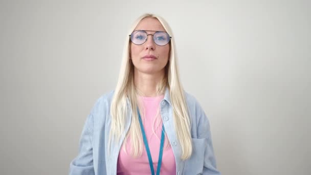 Junge Blonde Frau Lächelt Selbstbewusst Und Zeigt Mit Den Fingern — Stockvideo