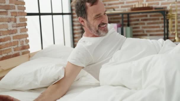 Orta Yaşlı Bir Adam Yatak Odasında Kollarını Açarak Uyanıyor — Stok video