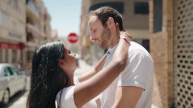 Man and woman interracial couple dancing at street