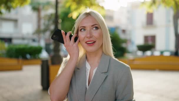 Junge Blonde Frau Hört Audiobotschaft Mit Dem Smartphone Park — Stockvideo