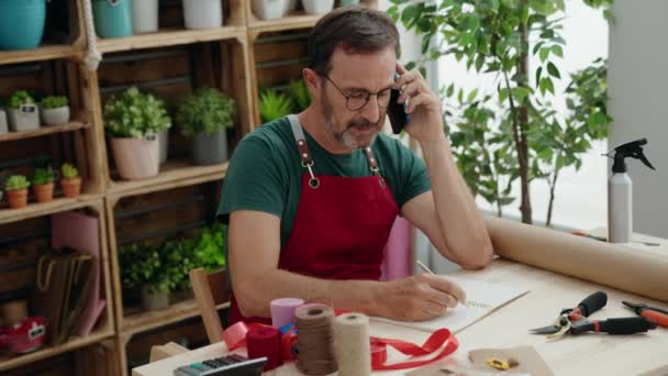 Middle Age Man Florist Talking Smartphone Writing Notebook Florist — Vídeos de Stock