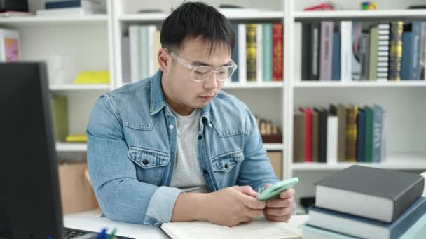 Jovem Chinês Homem Estudante Usando Smartphone Sentado Mesa Universidade Biblioteca — Vídeo de Stock