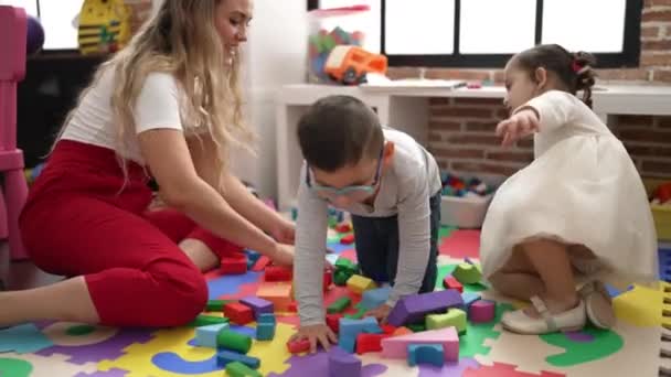 Lehrerin Mit Jungen Und Mädchen Beim Spielen Mit Bauklötzen Kindergarten — Stockvideo