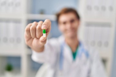 Genç Kafkasyalı doktor klinikte hap tutuyor.