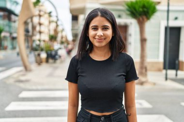 Sokakta kendine güvenen genç Latin kadın gülümsüyor