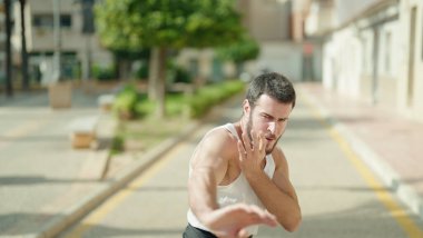 Genç İspanyol adam parkta karate dövüşçüsü eğitimi alıyor.