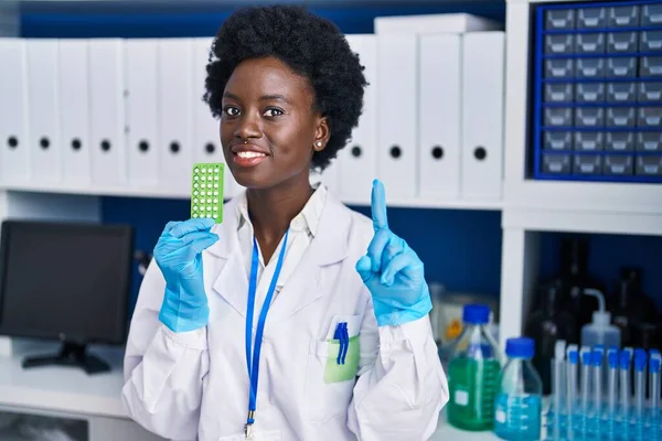 Mujer Joven Africana Que Trabaja Laboratorio Científico Sosteniendo Píldoras Anticonceptivas —  Fotos de Stock