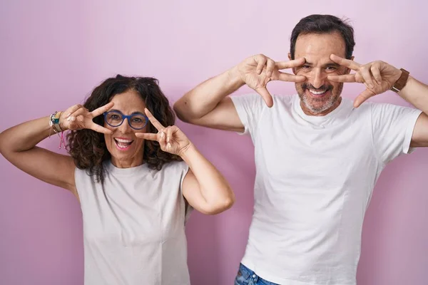Middelbare Leeftijd Hispanic Paar Samen Roze Achtergrond Doen Vrede Symbool — Stockfoto