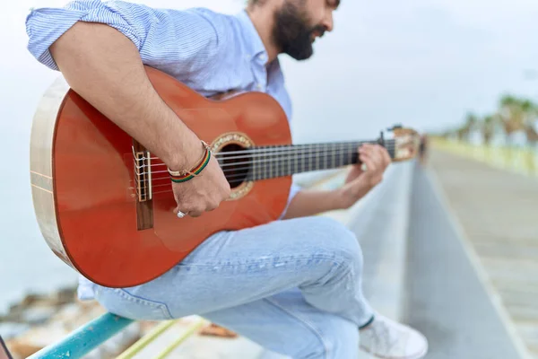 Young Hispanic Man Musician Playing Classical Guitar Sitting Balustrade Seaside — Stockfoto