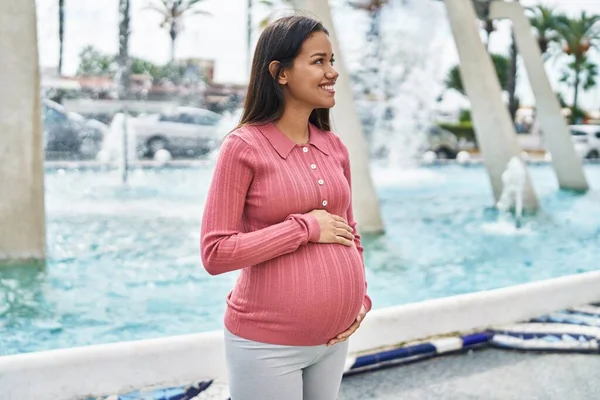 Młoda Latynoska Kobieta Ciąży Uśmiecha Się Pewnie Dotykając Brzucha Ulicy — Zdjęcie stockowe