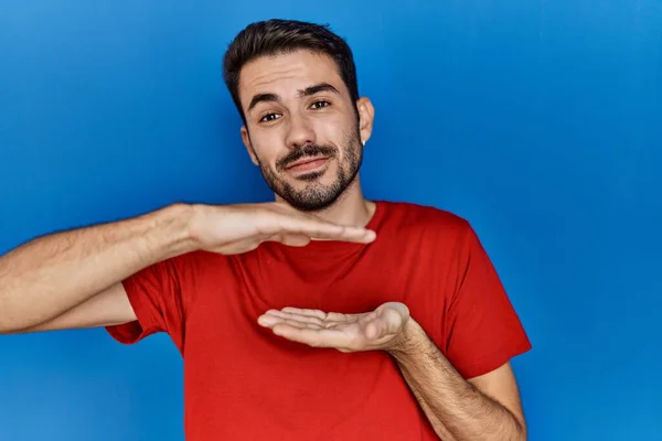 Jovem Hispânico Com Barba Vestindo Camiseta Vermelha Sobre Fundo Azul — Fotografia de Stock