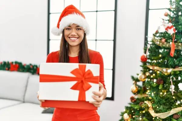 Young Latin Woman Unboxing Gift Standing Christmas Tree Home — ストック写真