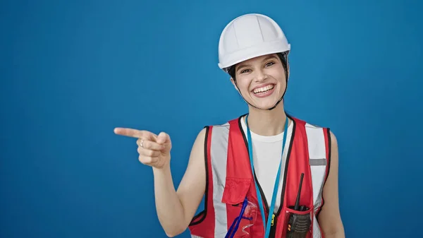Junge Schöne Hispanische Bauarbeiterin Lächelt Selbstbewusst Und Zeigt Zur Seite — Stockfoto