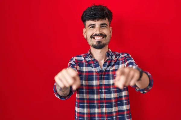 Kırmızı Arka Planda Sakallı Genç Spanyol Adam Seni Kamerayı Işaret — Stok fotoğraf