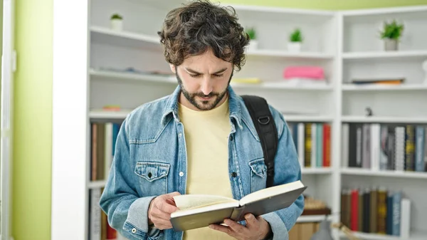 Jovem Estudante Hispânico Vestindo Mochila Leitura Livro Universidade Biblioteca — Fotografia de Stock