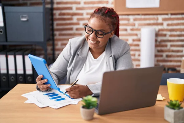 アフリカ系アメリカ人の女性ビジネスワーカーがオフィスでの書類にタッチパッドを使って — ストック写真