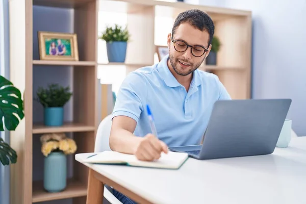 Young Man Using Laptop Writing Notebook Home —  Fotos de Stock