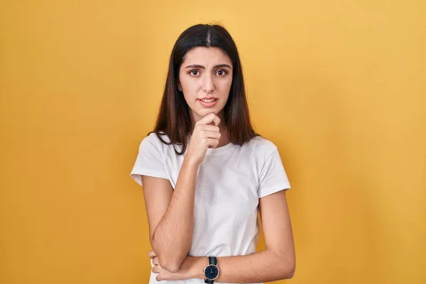 Sarı Arka Planda Duran Genç Güzel Bir Kadın Bir Soru — Stok fotoğraf