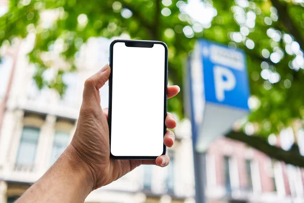 Mężczyzna Gospodarstwa Smartfon Pokazując Biały Pusty Ekran Parkingu — Zdjęcie stockowe