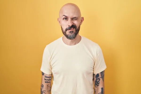 Homem Hispânico Com Tatuagens Sobre Fundo Amarelo Piscando Olhando Para — Fotografia de Stock