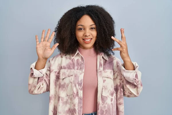 Młoda Afroamerykanka Stojąca Nad Niebieskim Tłem Pokazująca Wskazująca Palcami Numer — Zdjęcie stockowe