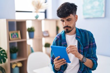 Genç İspanyol adam evdeki dokunmatik kağıda yazı yazıyor.